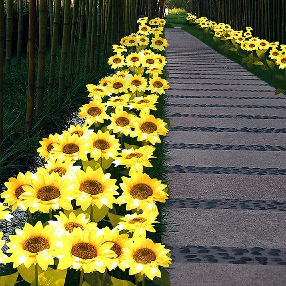 Two solar-powered sunflower lights in a garden setting, showcasing their vibrant yellow color and elegant design.