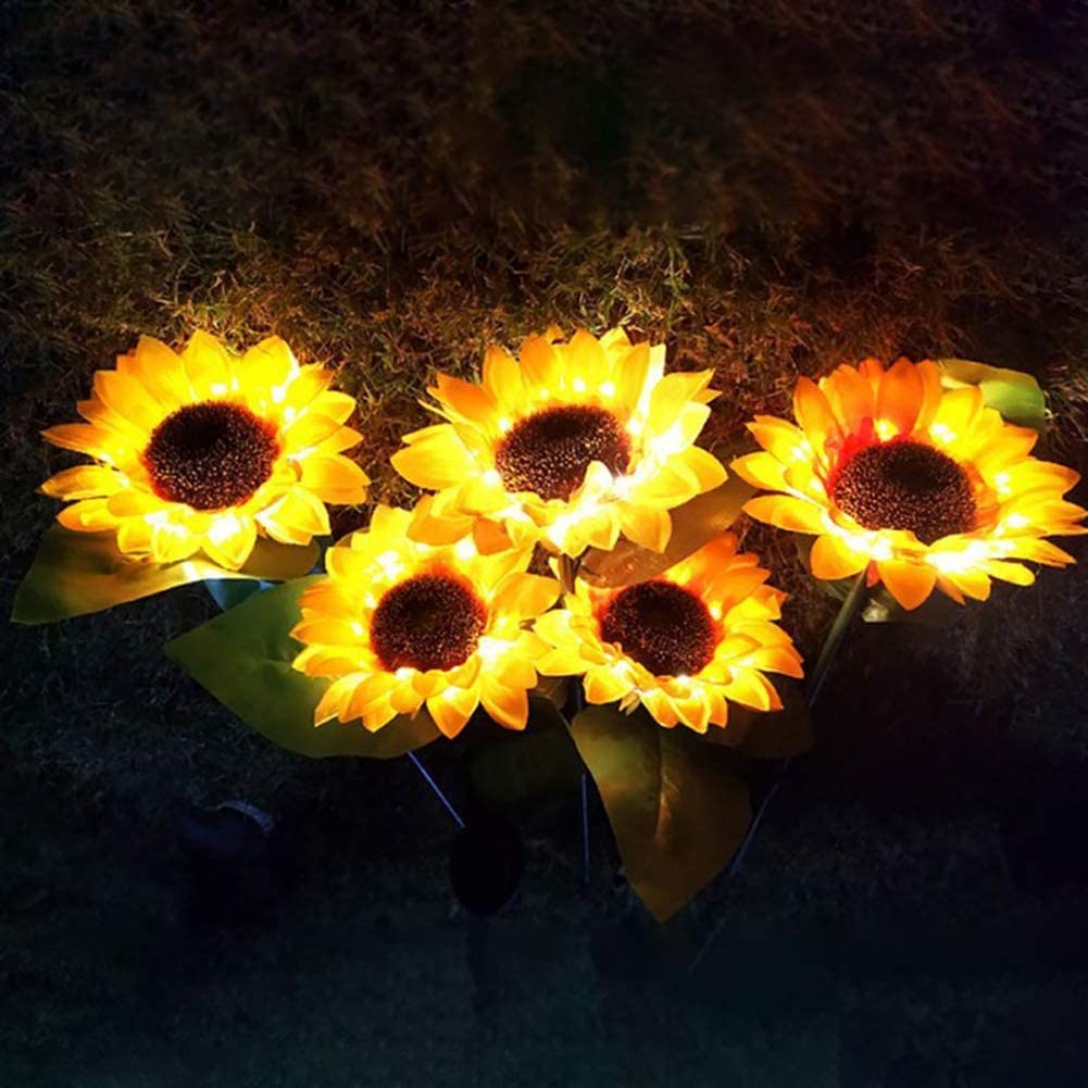 Two solar-powered sunflower lights in a garden setting, showcasing their vibrant yellow color and elegant design.