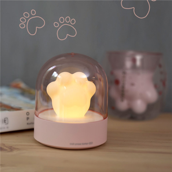 A cute cat paw-shaped night light with soft glowing light and a music box feature, perfect for home decor.