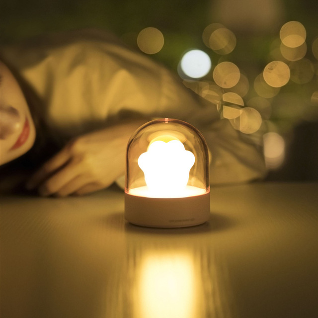 A cute cat paw-shaped night light with soft glowing light and a music box feature, perfect for home decor.