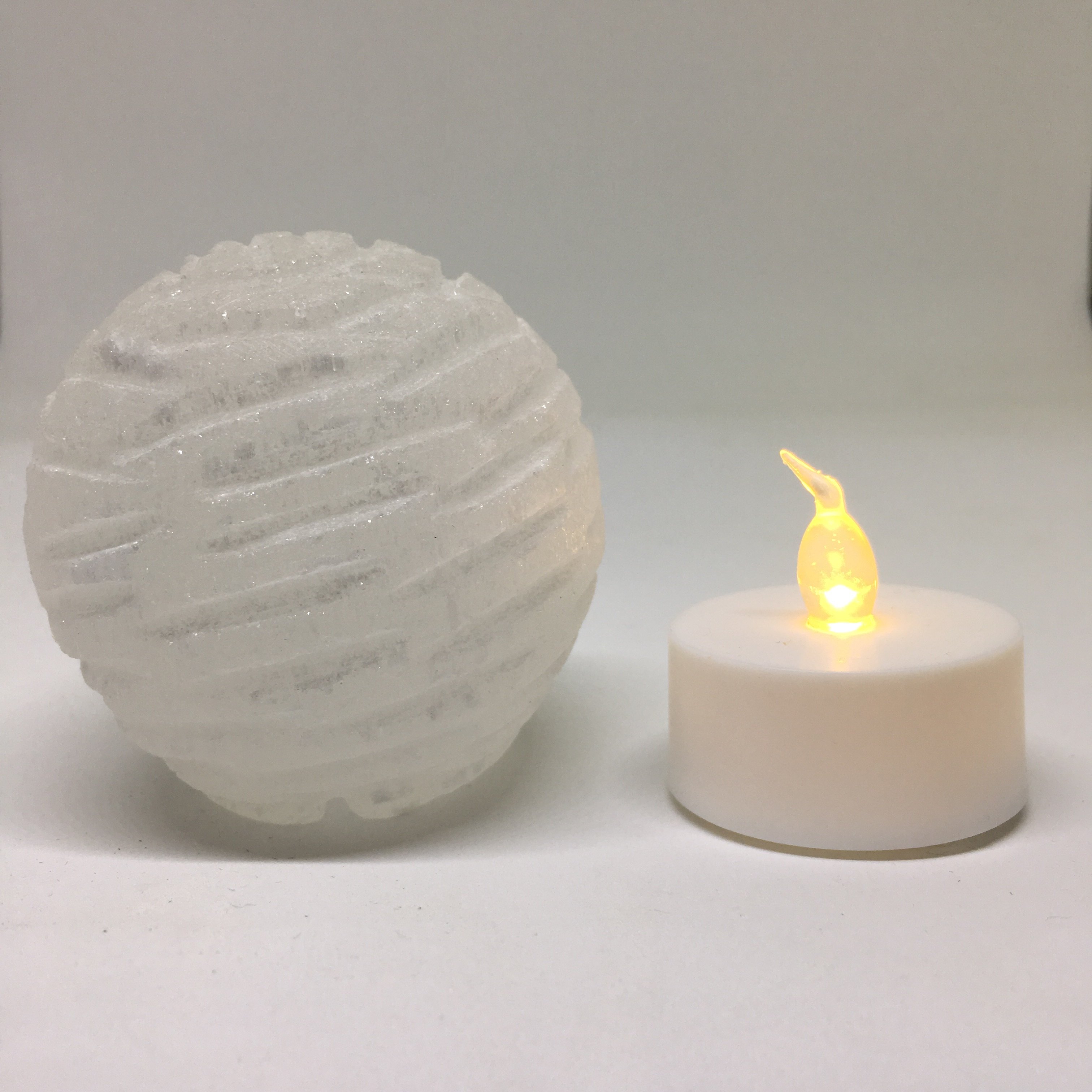 A beautifully crafted Selenite Bubble Lamp with a warm yellow LED flame, showcasing its unique hand-cut design by Moroccan artisans.