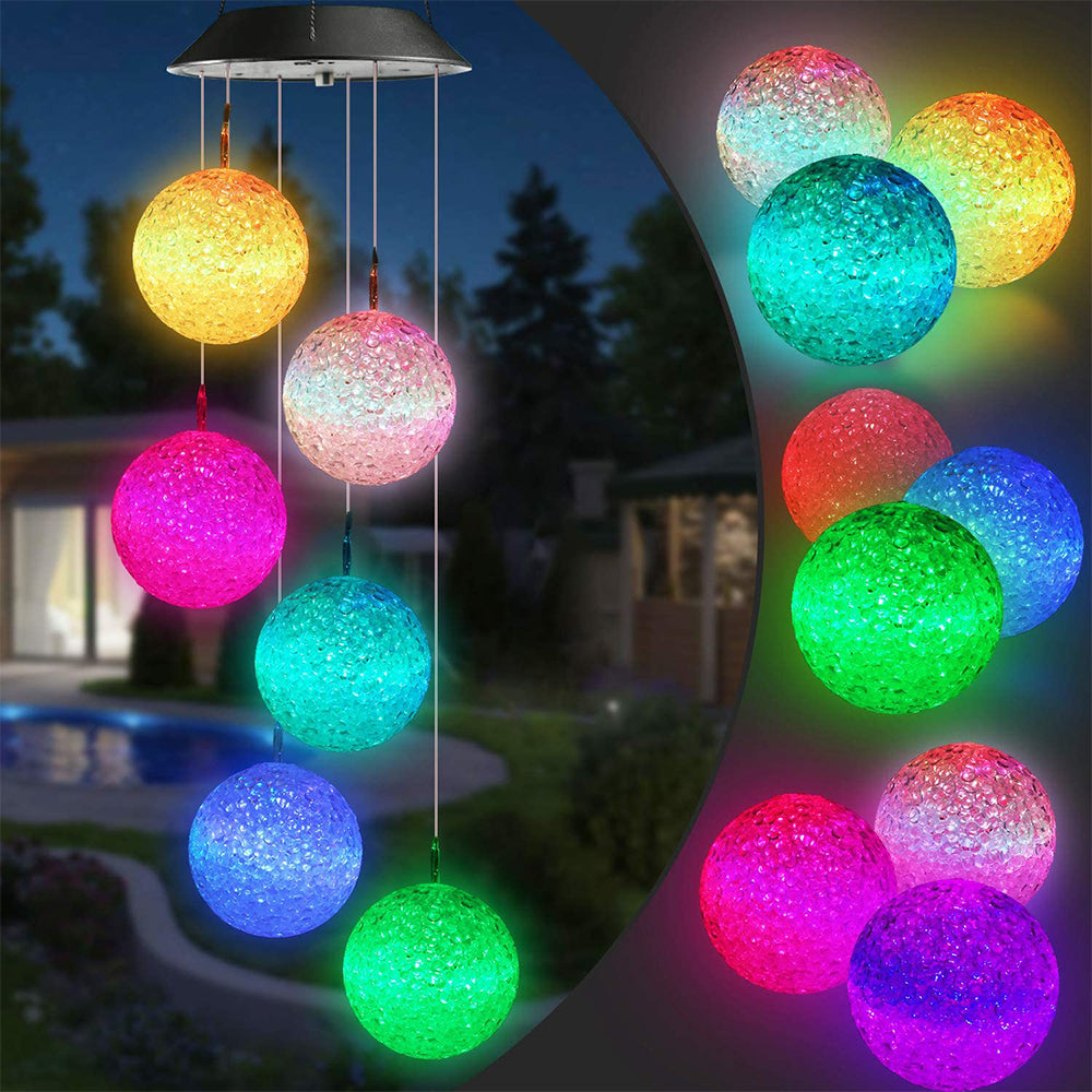 Colorful Solar Crystal Ball Wind Chime Light hanging in a garden, showcasing its vibrant LED lights and glassy design.