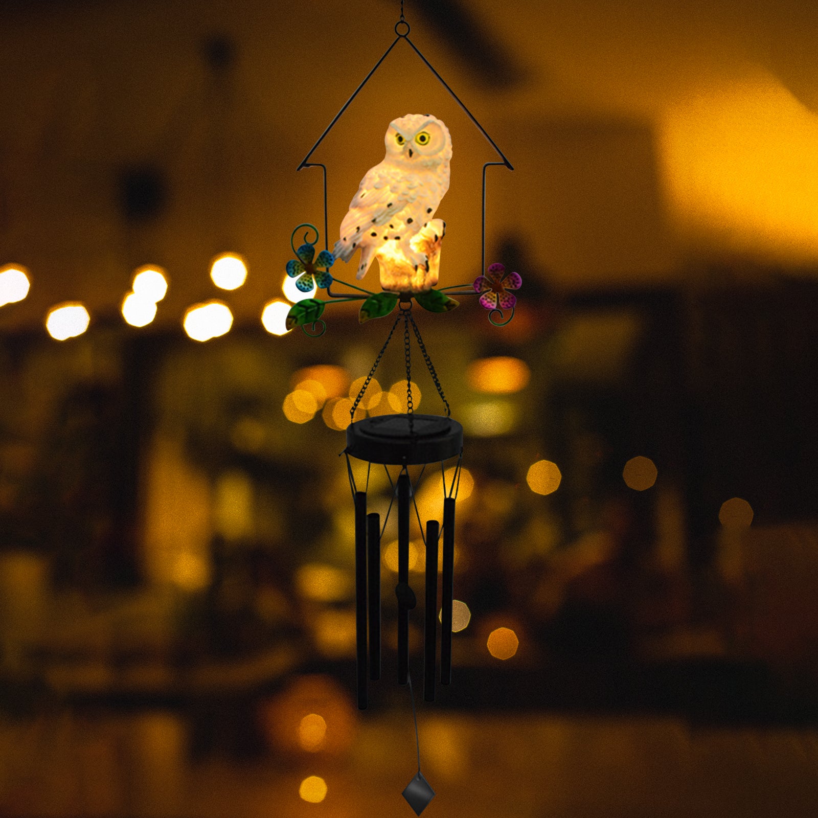 A beautifully crafted solar owl wind chime light featuring a lifelike owl sculpture atop metal chimes, glowing softly at night.