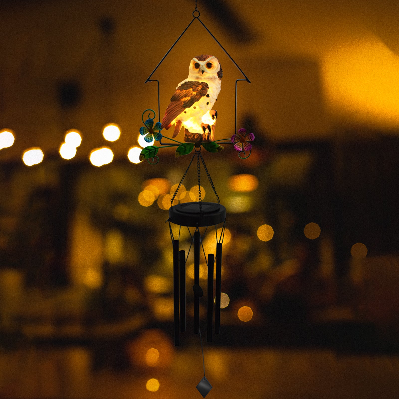 A beautifully crafted solar owl wind chime light featuring a lifelike owl sculpture atop metal chimes, glowing softly at night.