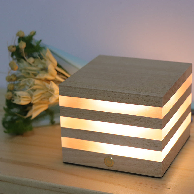 A beautifully crafted wooden rechargeable LED night light emitting a warm glow, perfect for cozy interiors.