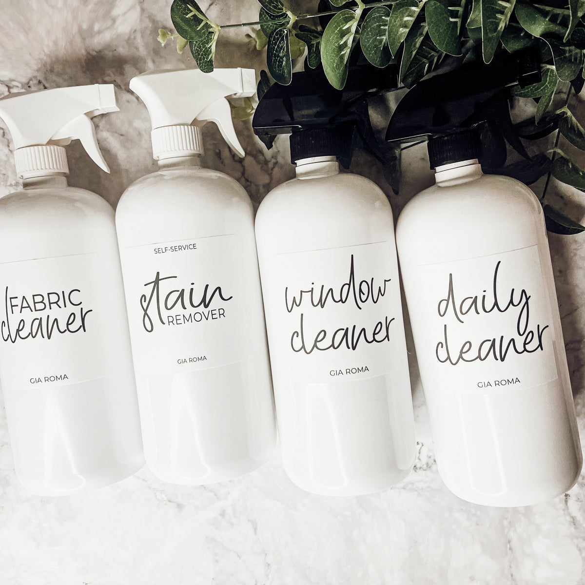 A set of 32oz white plastic cleaning bottles with spray pumps, showcasing their sleek design and customizable waterproof labels.