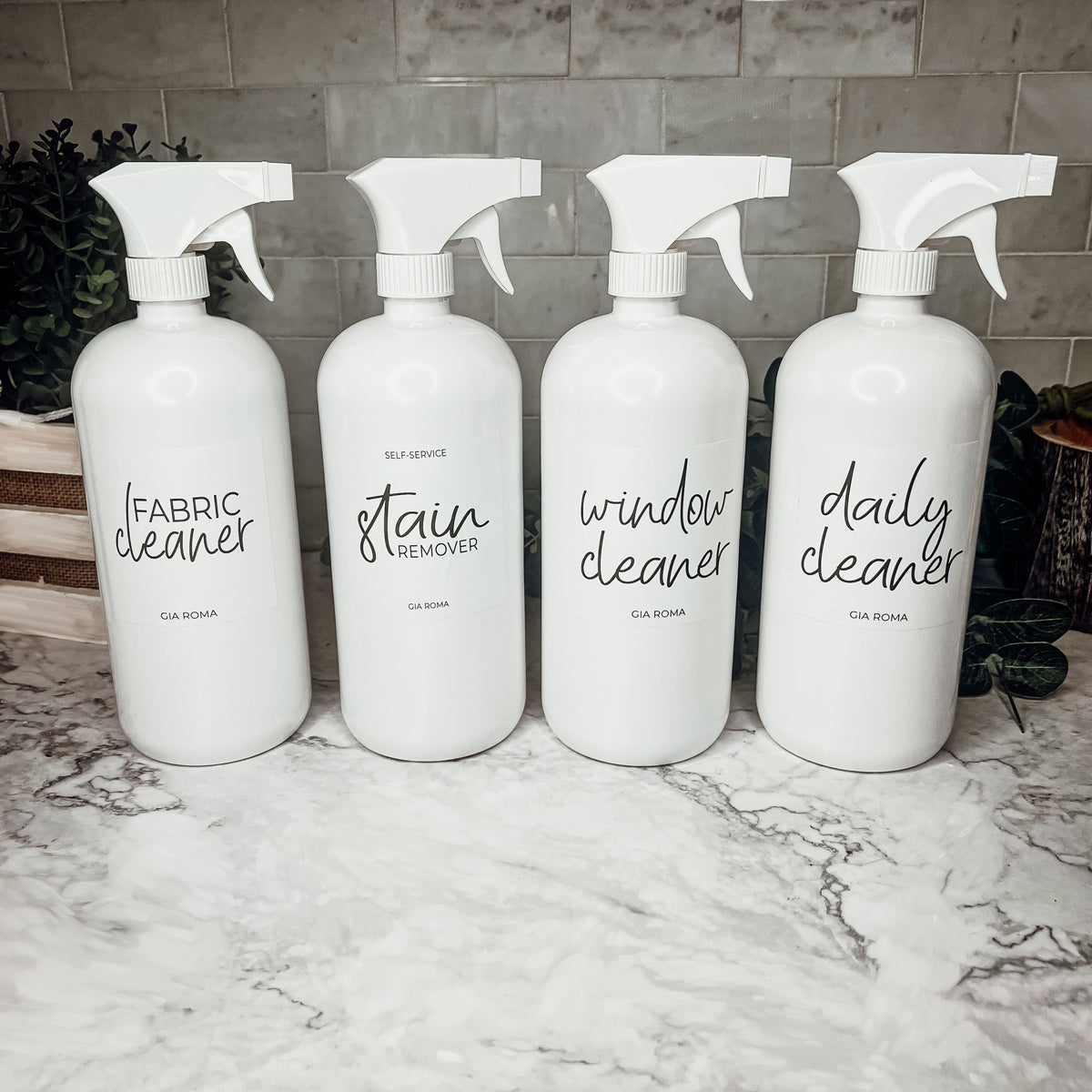 A set of 32oz white plastic cleaning bottles with spray pumps, showcasing their sleek design and customizable waterproof labels.