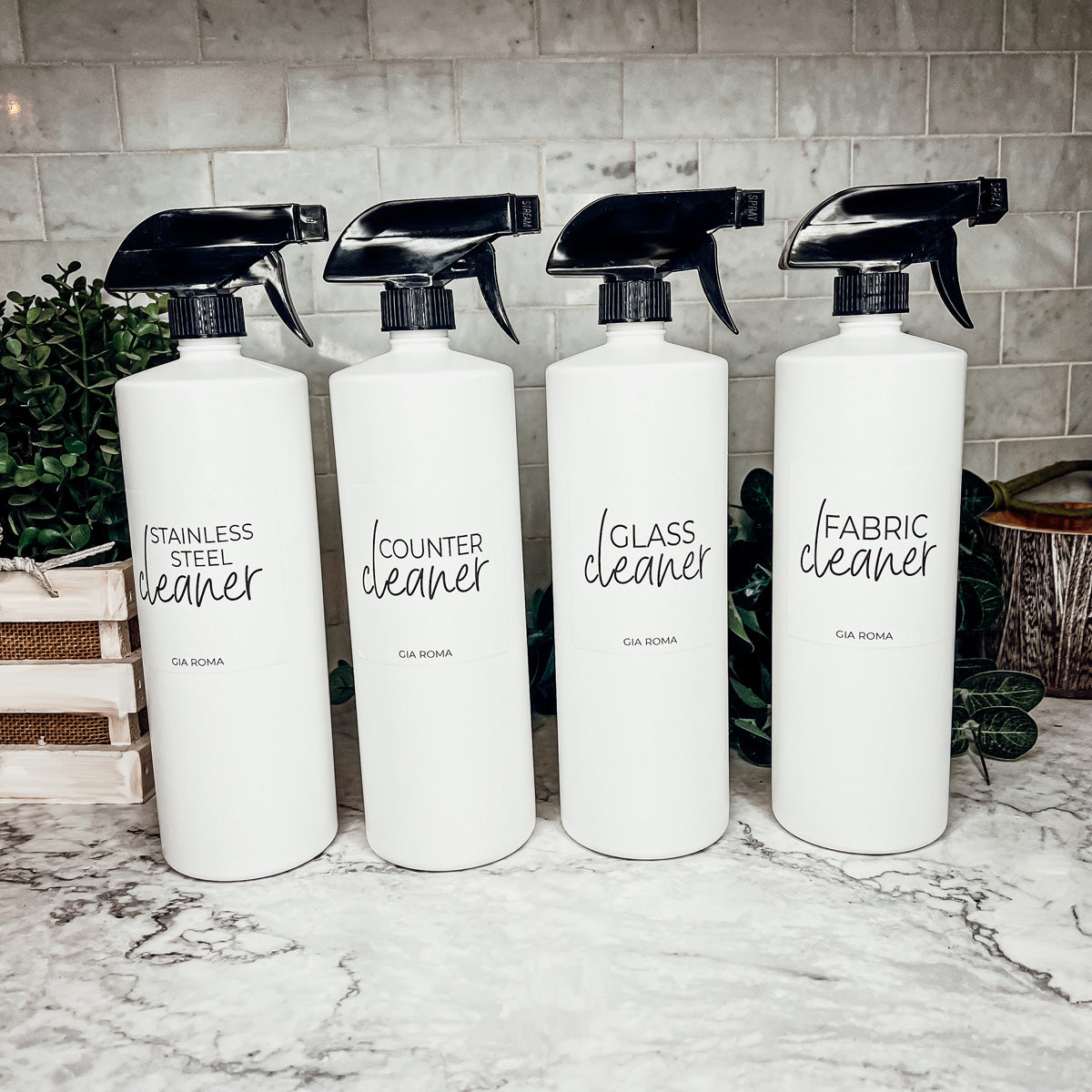 A set of 32oz white plastic cleaning bottles with spray pumps, showcasing their sleek design and customizable waterproof labels.