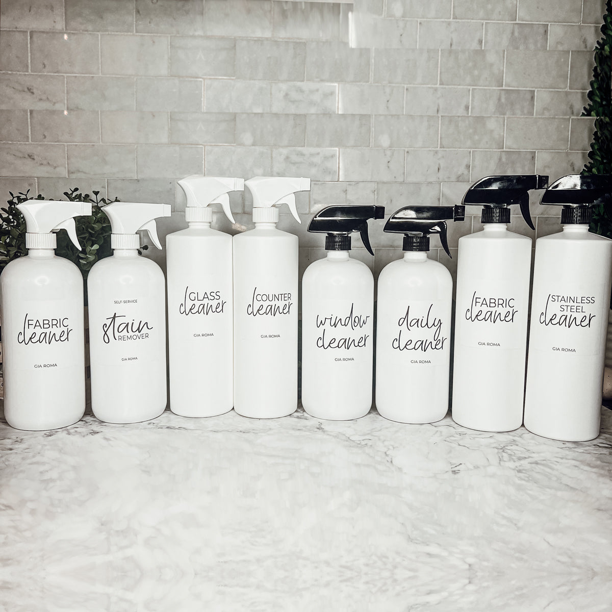 A set of 32oz white plastic cleaning bottles with spray pumps, showcasing their sleek design and customizable waterproof labels.