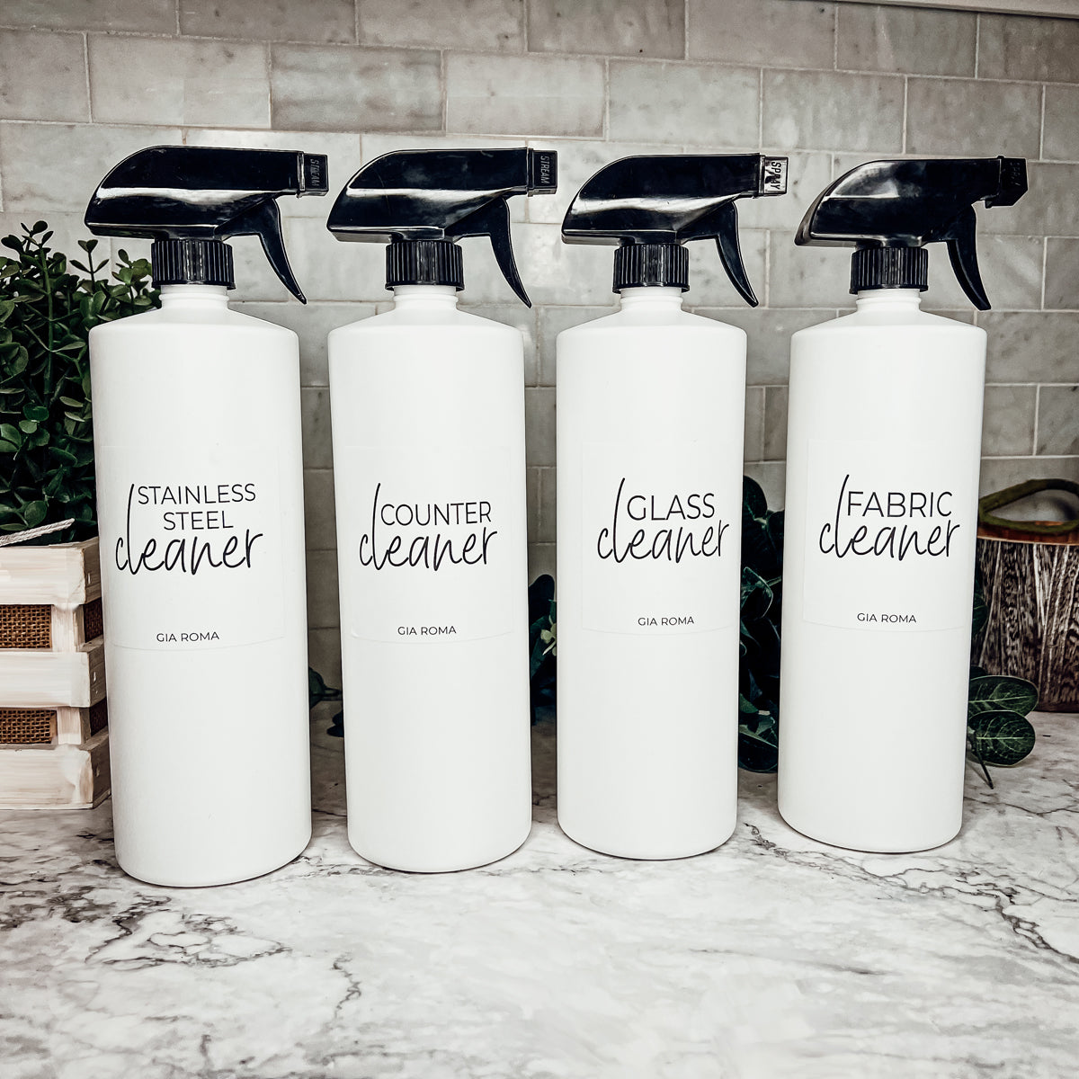 A set of 32oz white plastic cleaning bottles with spray pumps, showcasing their sleek design and customizable waterproof labels.