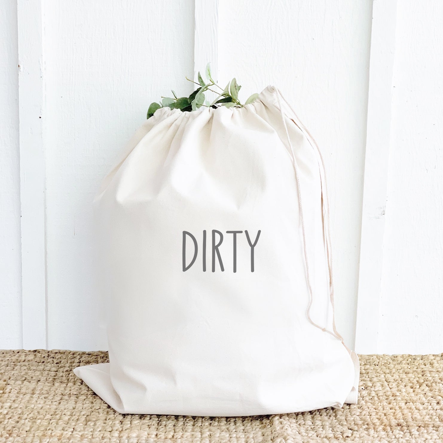 A durable canvas laundry bag with a drawstring closure, featuring a cotton webbing handle and printed designs, available in two sizes.