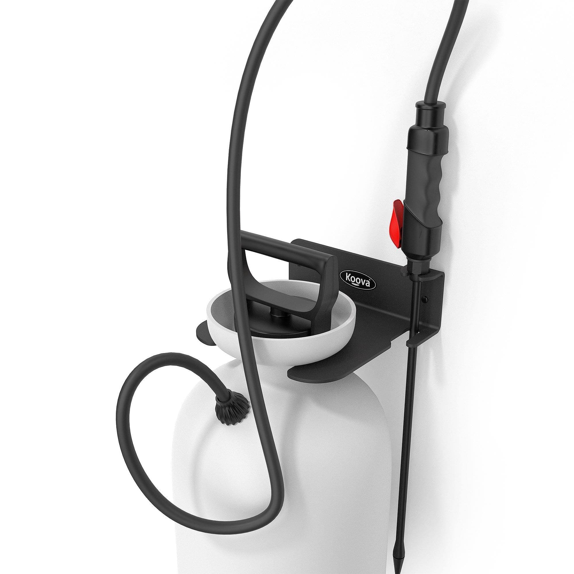 A wall-mounted garden sprayer holder made of heavy gauge steel, featuring a black powder-coated finish, securely holding a pressure sprayer in a garage setting.