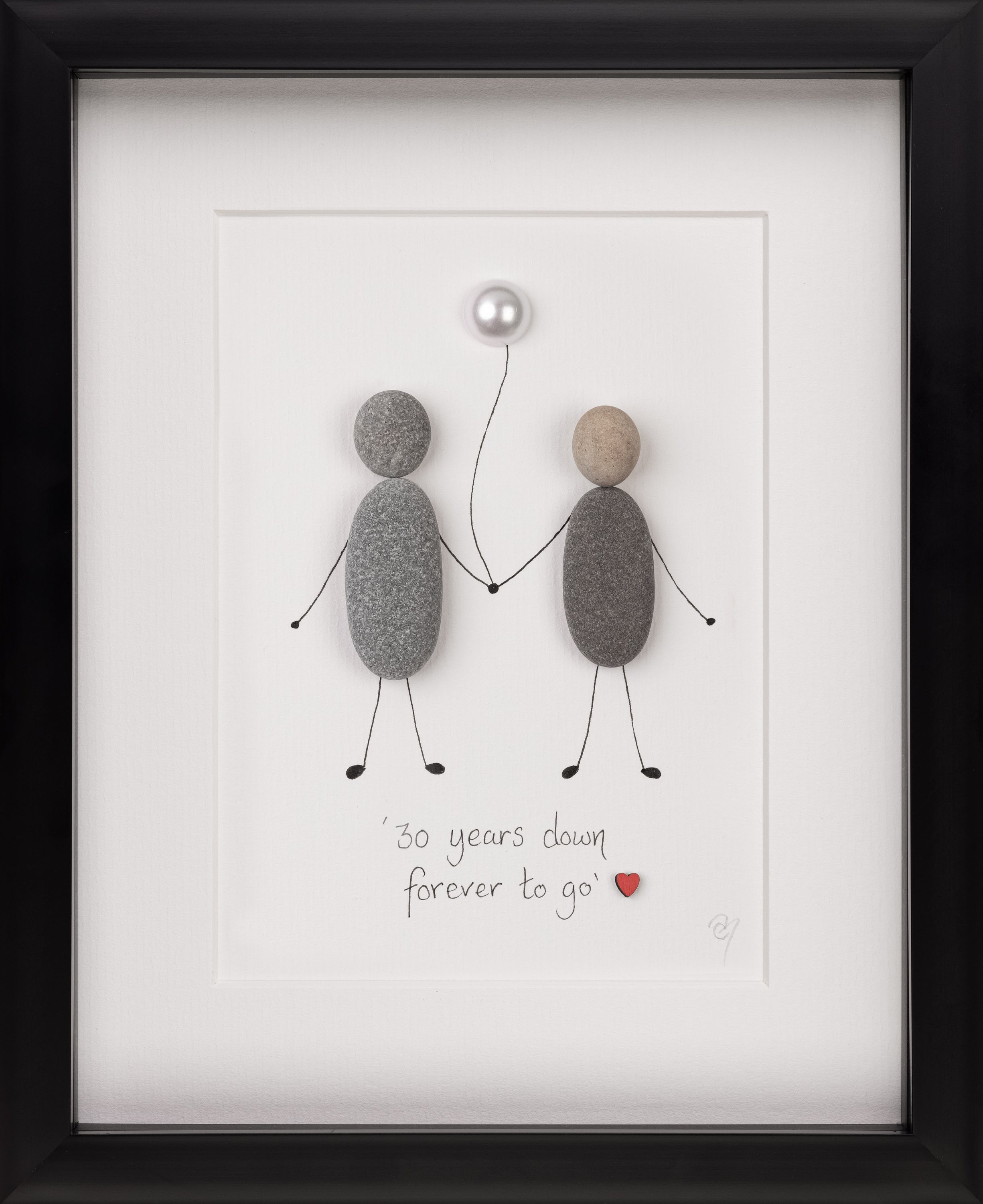 A beautifully framed pebble art piece celebrating anniversaries, featuring customizable designs with pebbles arranged to symbolize love and commitment.