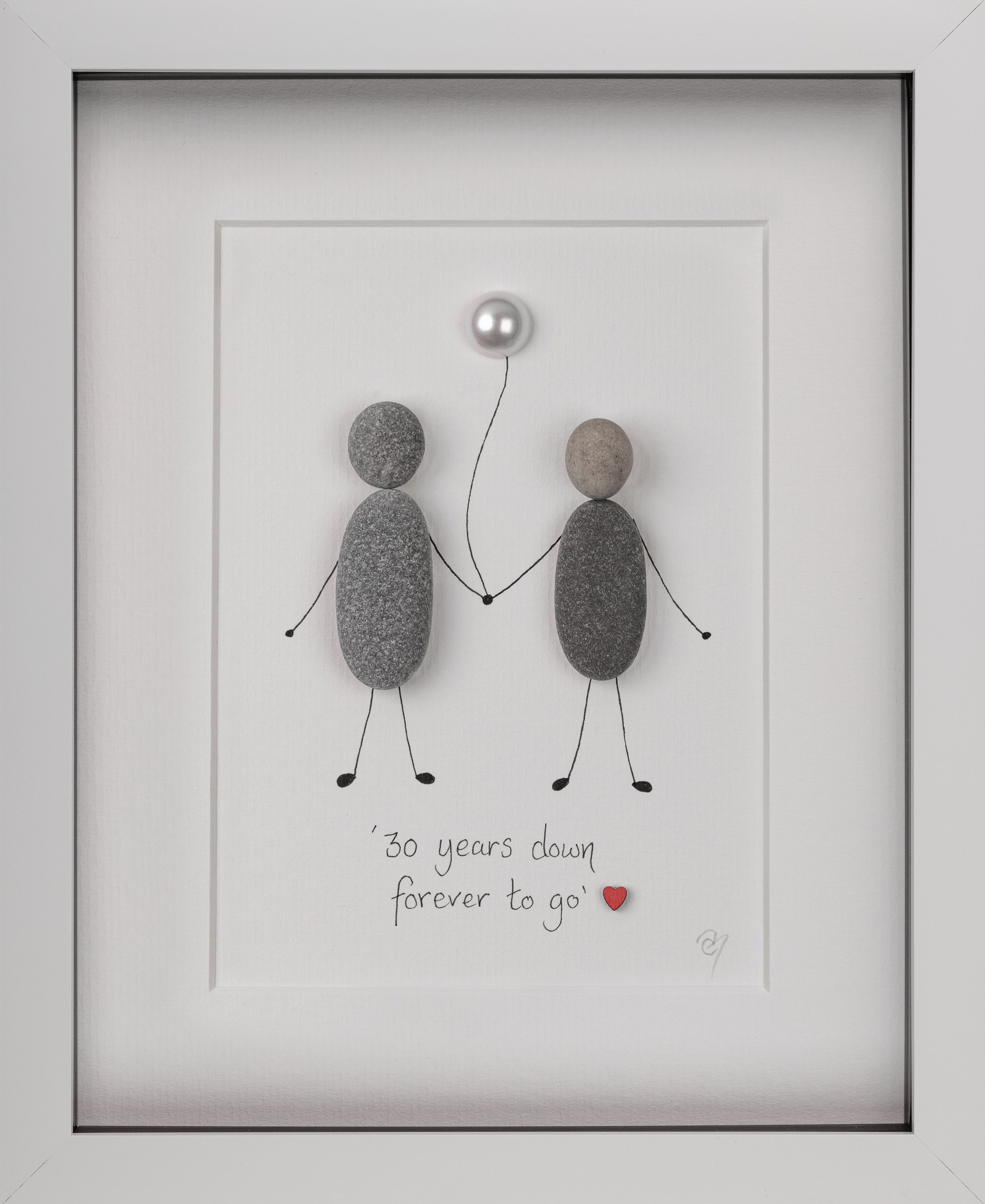 A beautifully framed pebble art piece celebrating anniversaries, featuring customizable designs with pebbles arranged to symbolize love and commitment.