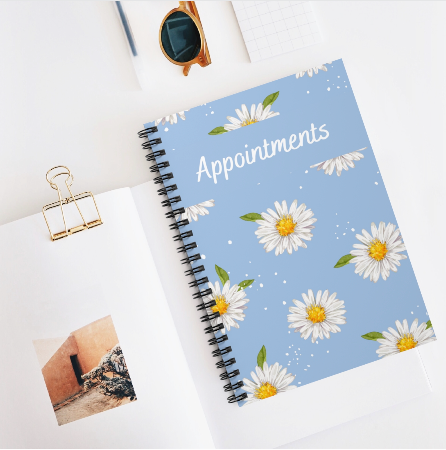 A floral-themed A5 appointment book with a spiral binding and laminated cover, showcasing vibrant flowers on the front.