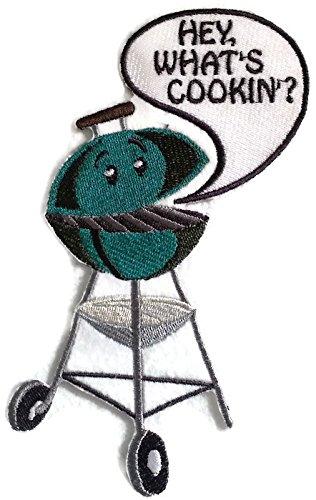 Hey What's Cooking In embroidered patch on a fabric background, showcasing vibrant colors and intricate stitching.