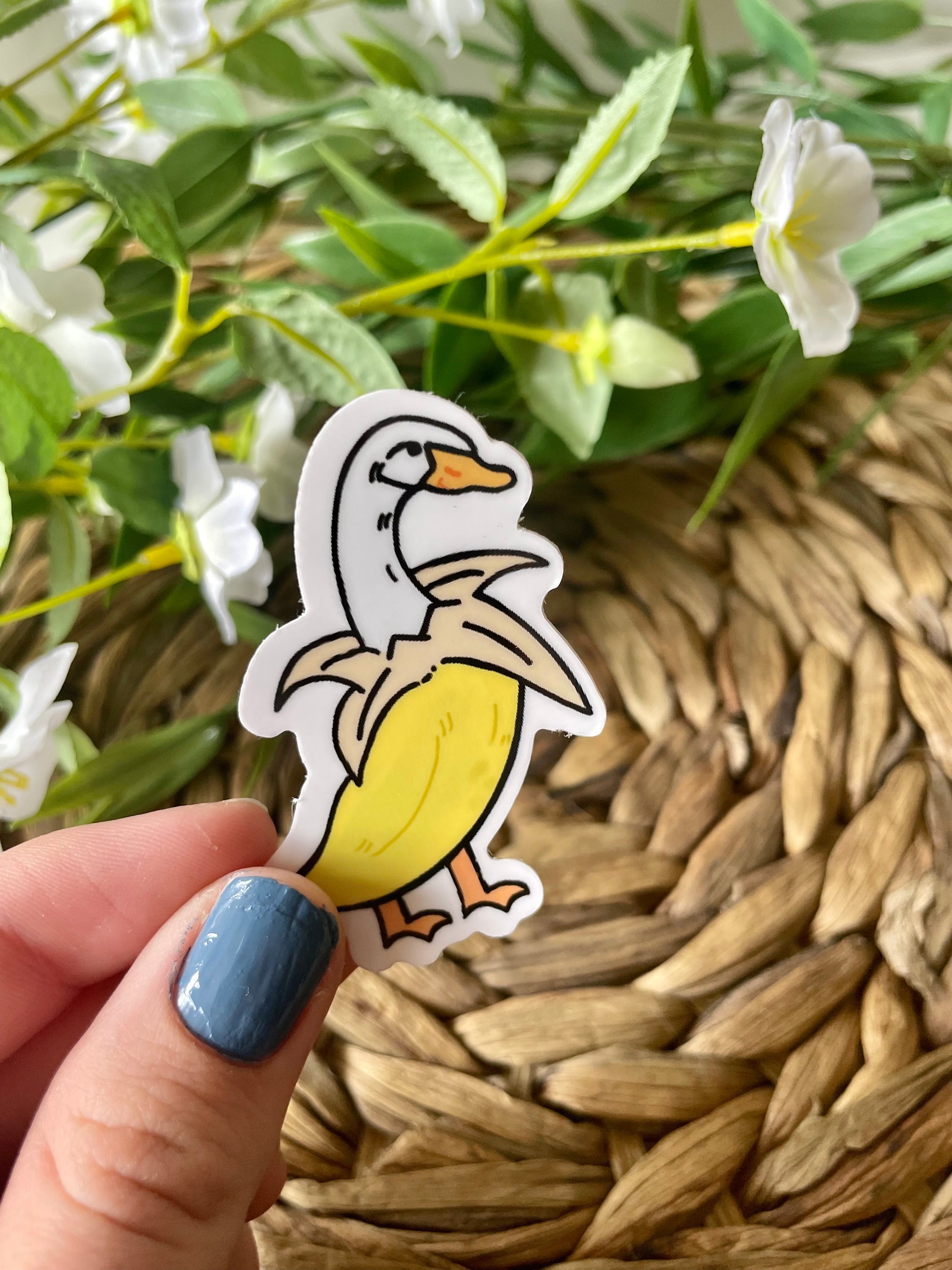 A cute banana duck sticker featuring a whimsical design, available in white and purple options, perfect for personalizing items.