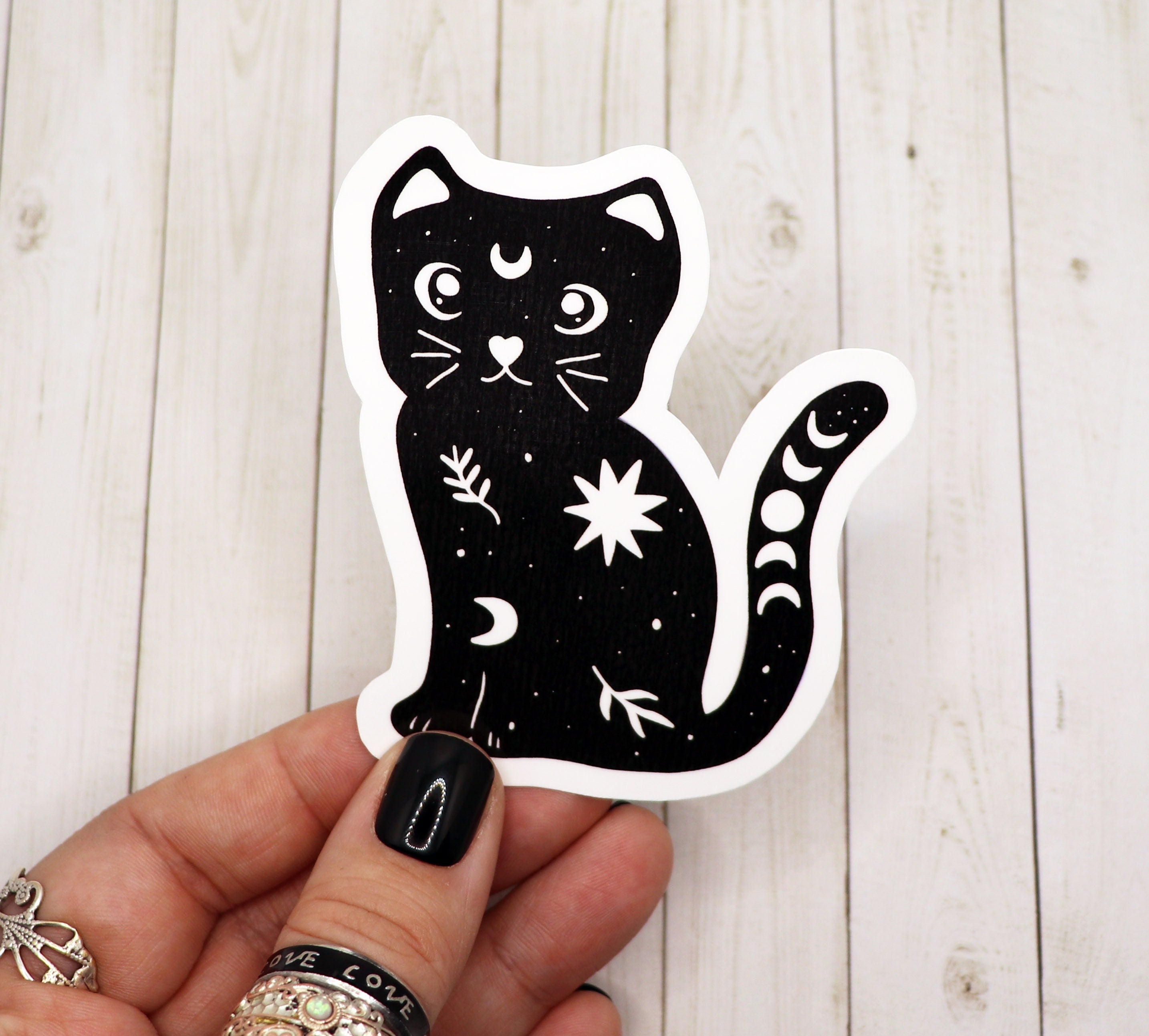 A beautifully designed black and white sticker featuring a celestial cat, perfect for personalizing various items.