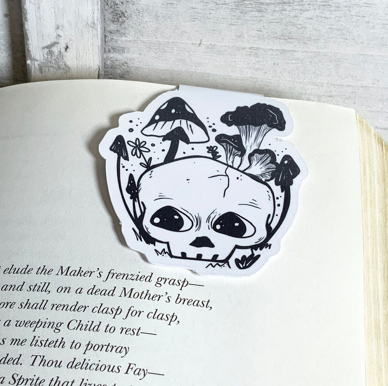 Black and white skull magnetic bookmark featuring a unique design, measuring 2 inches wide by 2.5 inches tall, ideal for avid readers.