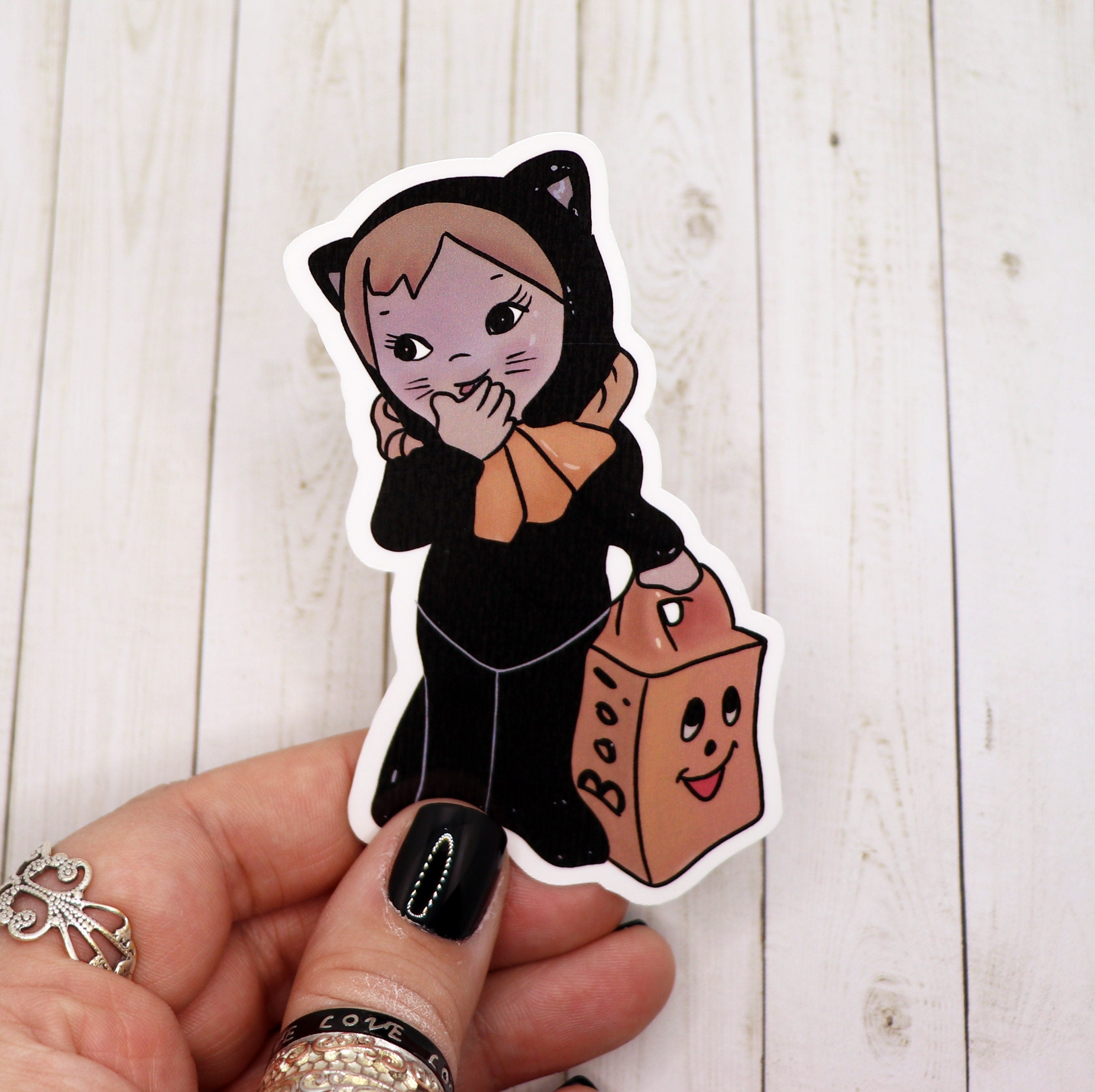 A cute retro sticker featuring a black cat girl holding a candy bag, perfect for personalizing items.