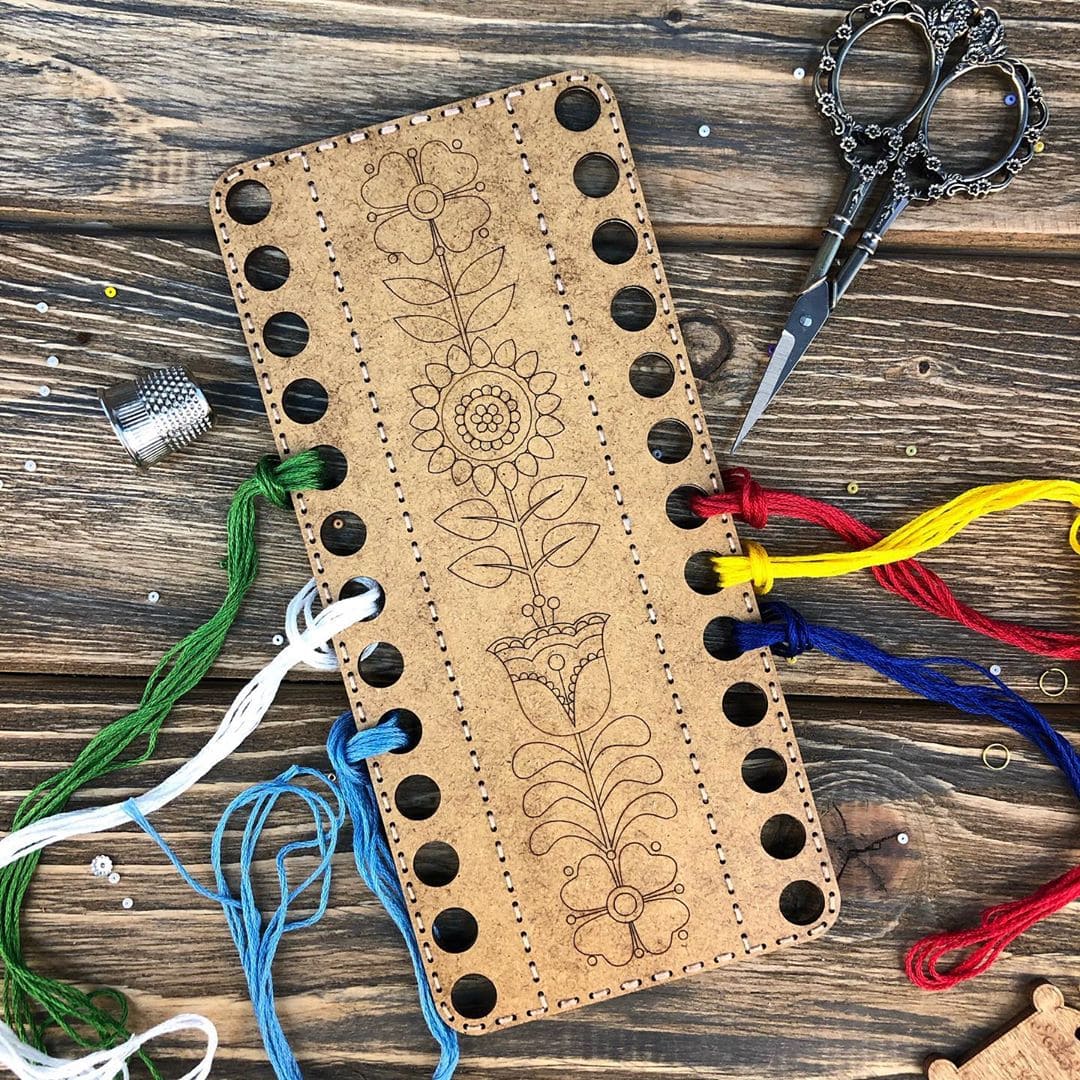 Wooden embroidery blank FLHW-019 with perforated design, thread, and needle for crafting.