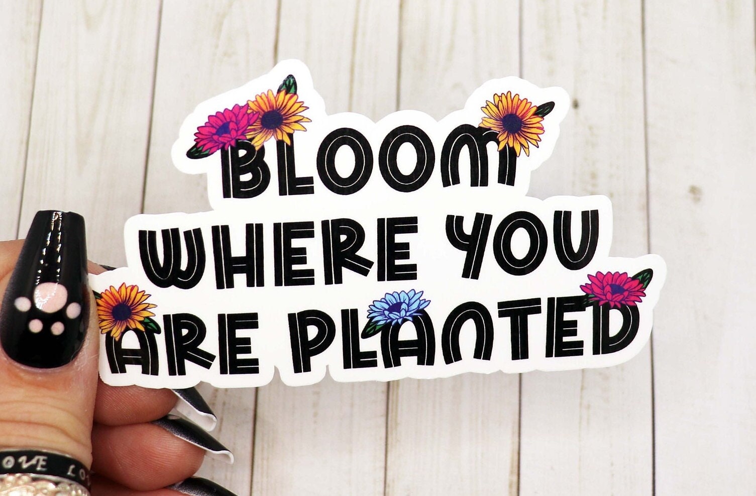 Bloom Where You Are Planted vinyl sticker on a white background, showcasing its vibrant design and matte finish.