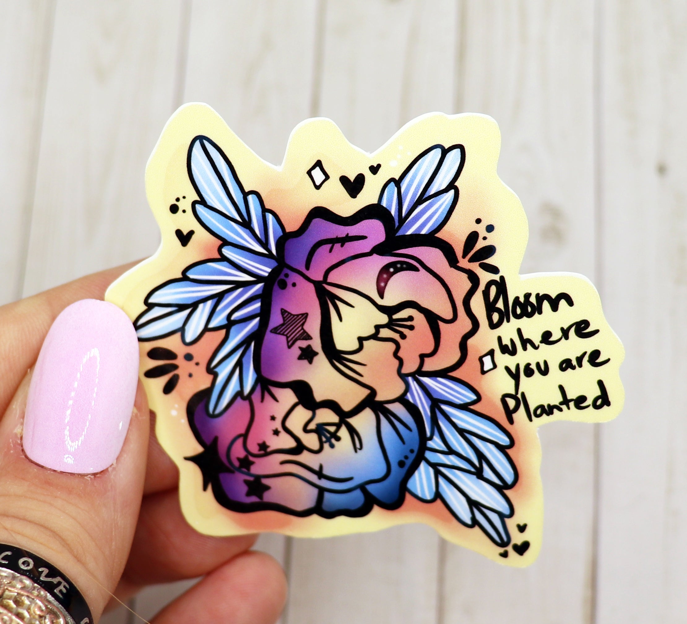 Bloom Where You Are Planted vinyl sticker on a white background, showcasing its vibrant design and matte finish.