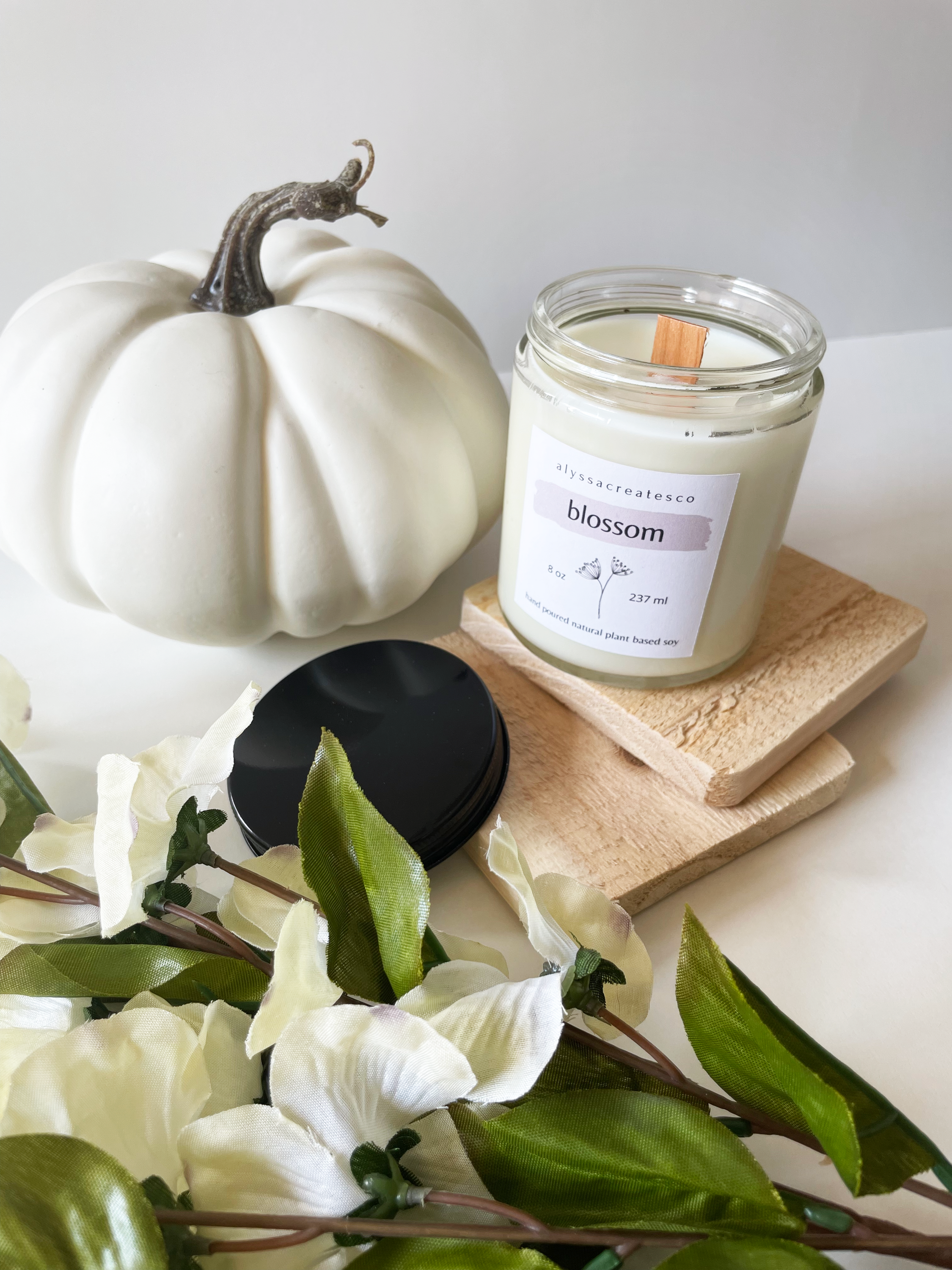 Blossom Wood Wick Candle in a glass jar with a wooden wick, showcasing its natural soy wax and floral scent.