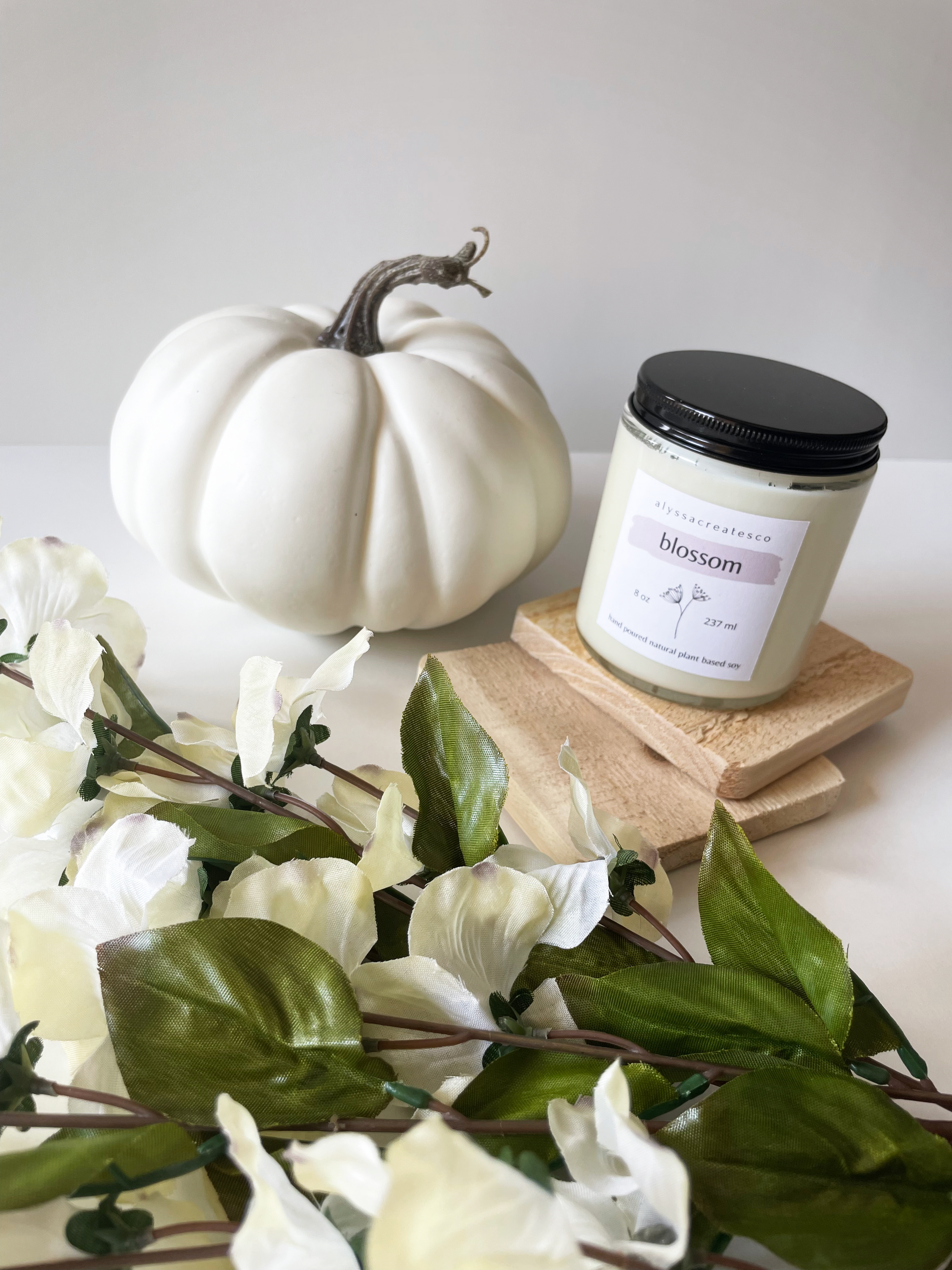 Blossom Wood Wick Candle in a glass jar with a wooden wick, showcasing its natural soy wax and floral scent.