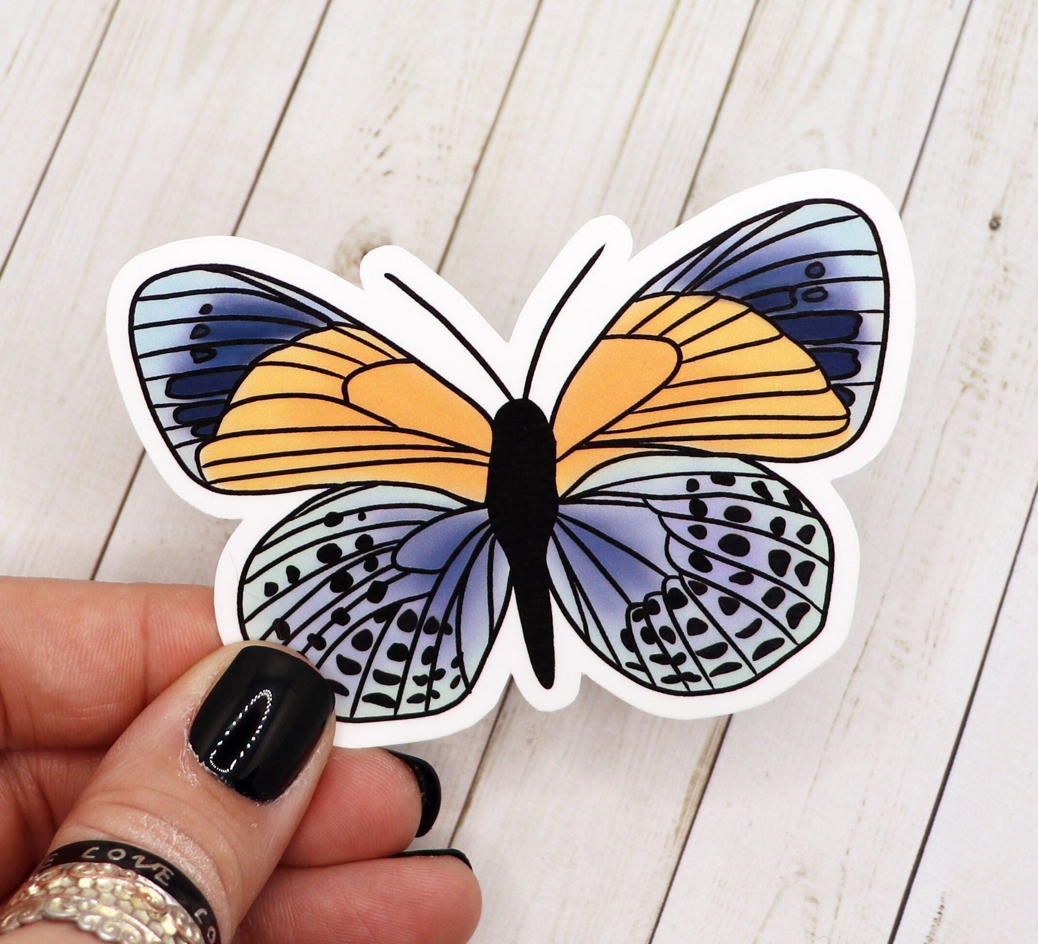 A vibrant blue and yellow butterfly vinyl sticker on a white background, showcasing its intricate design and colors.