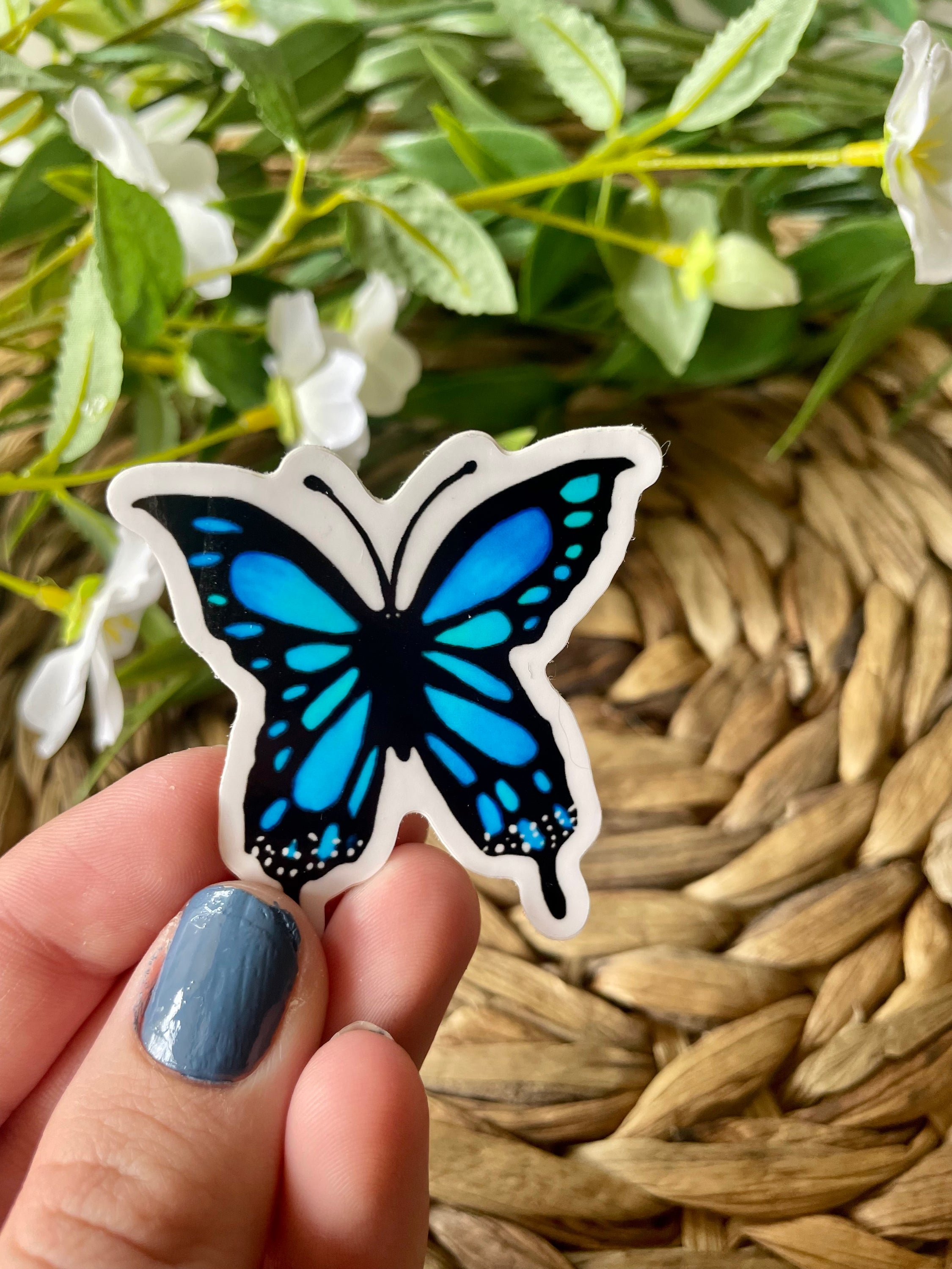 A vibrant blue butterfly sticker designed for customization, featuring intricate details and a glossy finish.