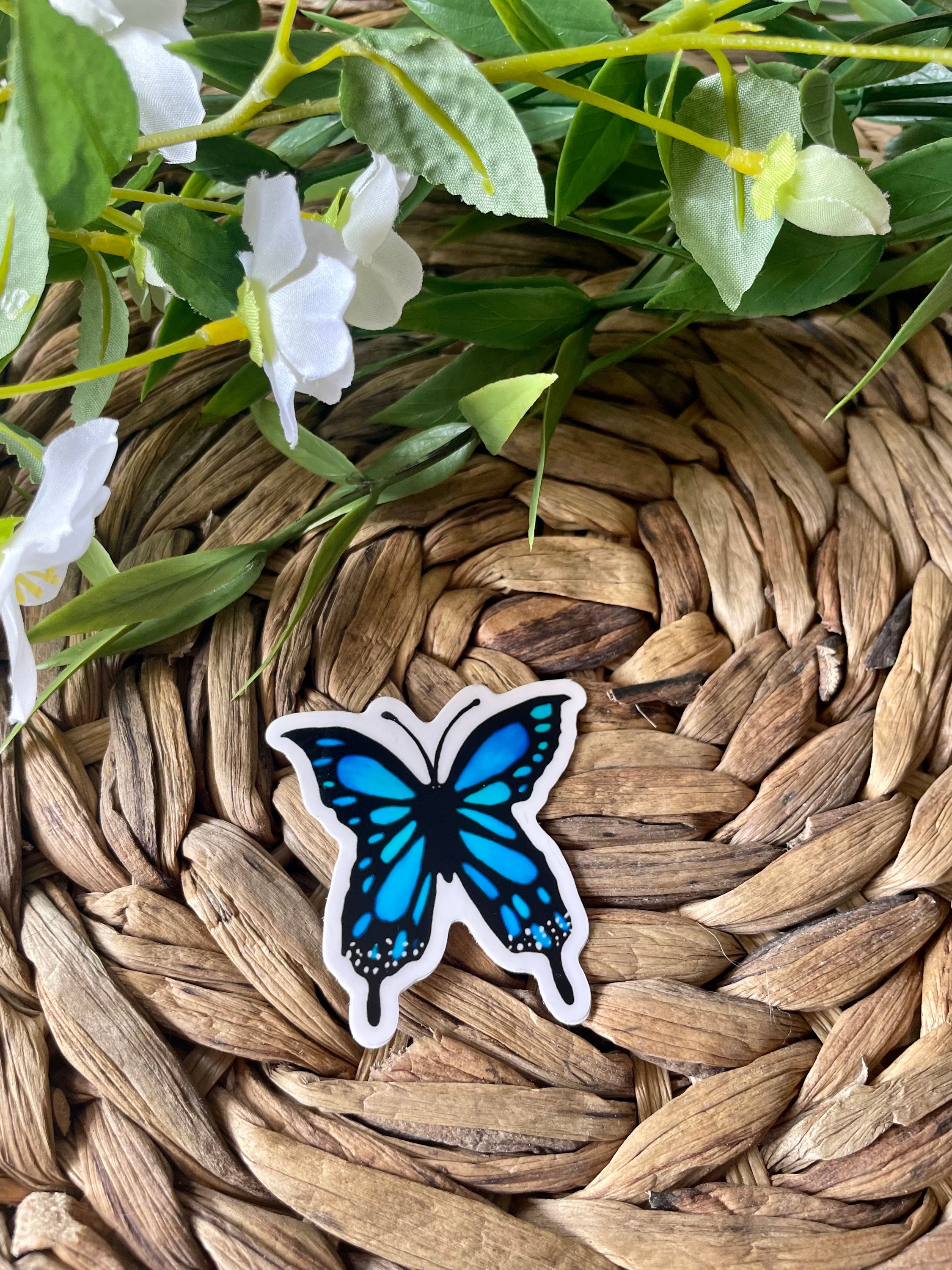 A vibrant blue butterfly sticker designed for customization, featuring intricate details and a glossy finish.