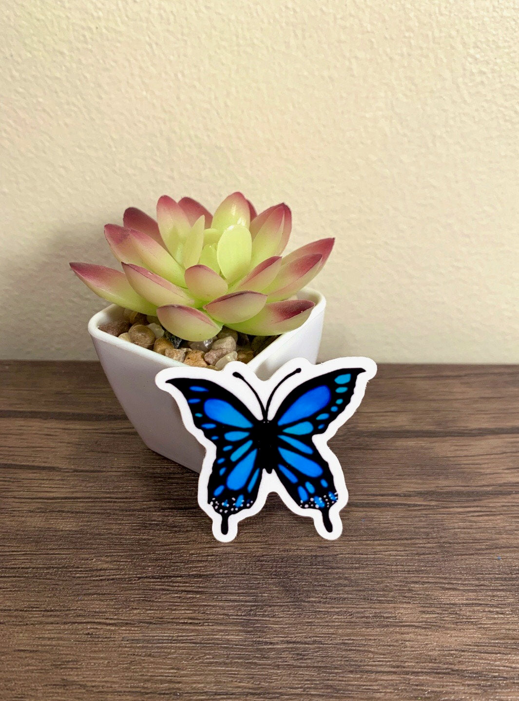 A vibrant blue butterfly sticker designed for customization, featuring intricate details and a glossy finish.