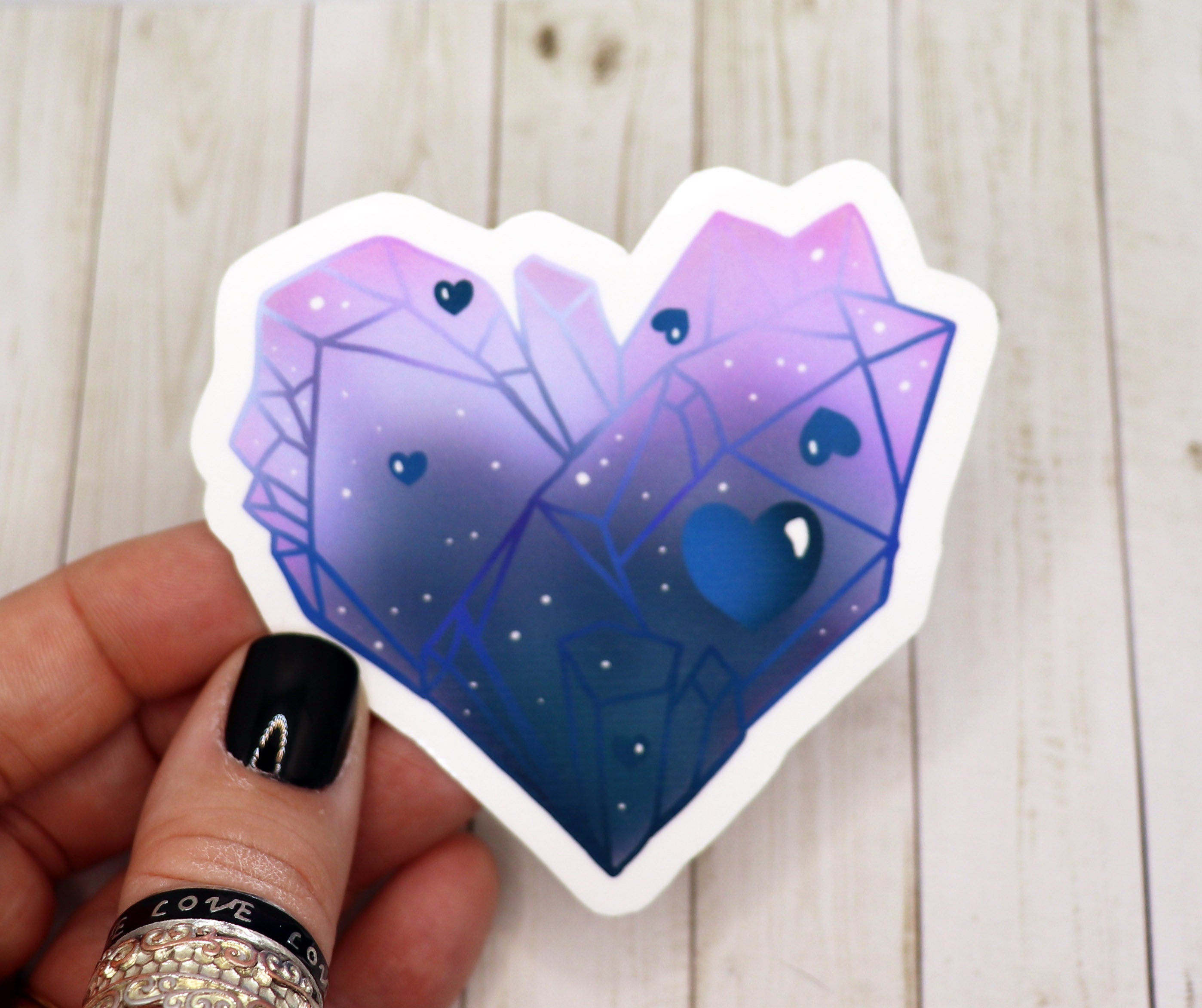 A vibrant blue crystal heart sticker on a white background, showcasing its glossy finish and intricate design.