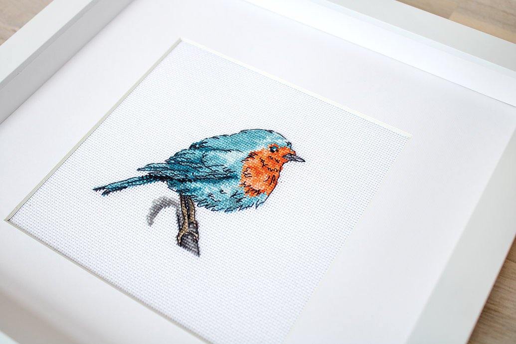 Bluebird B1167L Counted Cross-Stitch Kit featuring colorful threads, Zweigart fabric, and detailed instructions for stitching a charming bird design.