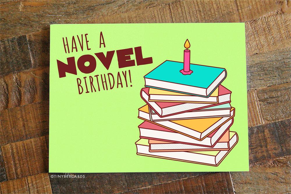 A colorful birthday card featuring the phrase 'Have a Novel Birthday!' designed for book lovers, with a matching white envelope.