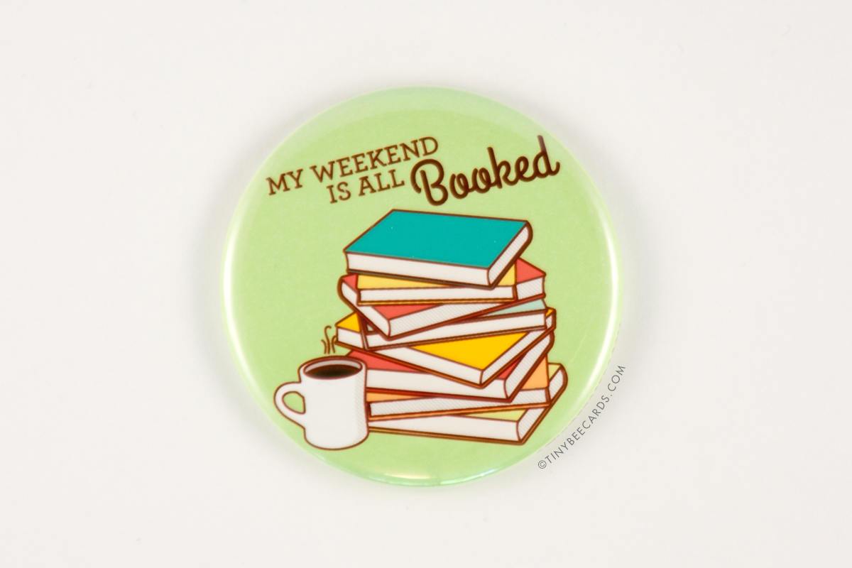 A colorful 2.25-inch round magnet featuring a pile of books and a coffee cup with the text 'My Weekend is All Booked!'