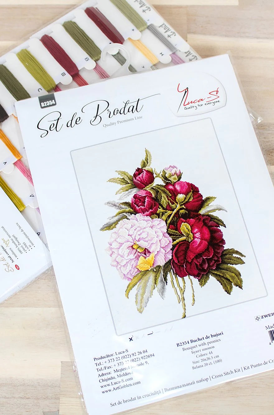 A counted cross-stitch kit featuring a beautiful peony bouquet design, including canvas, colorful threads, needle, and instructions.