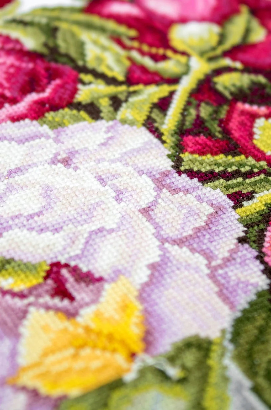 A counted cross-stitch kit featuring a beautiful peony bouquet design, including canvas, colorful threads, needle, and instructions.