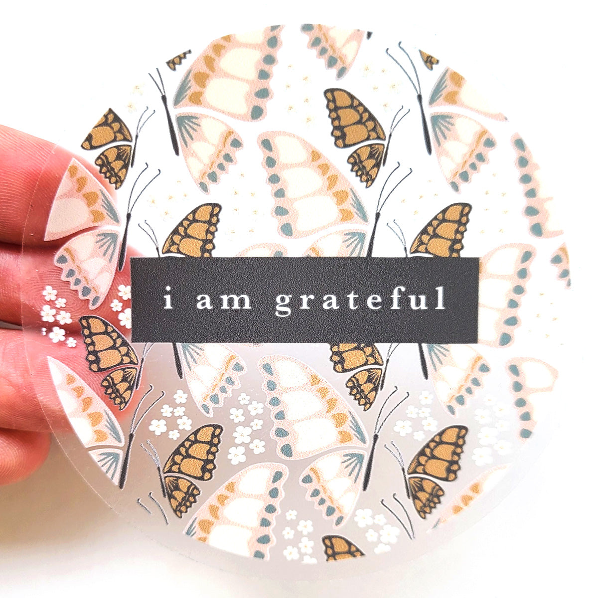 A 3-inch clear vinyl sticker featuring a butterfly design, symbolizing gratitude and positivity.