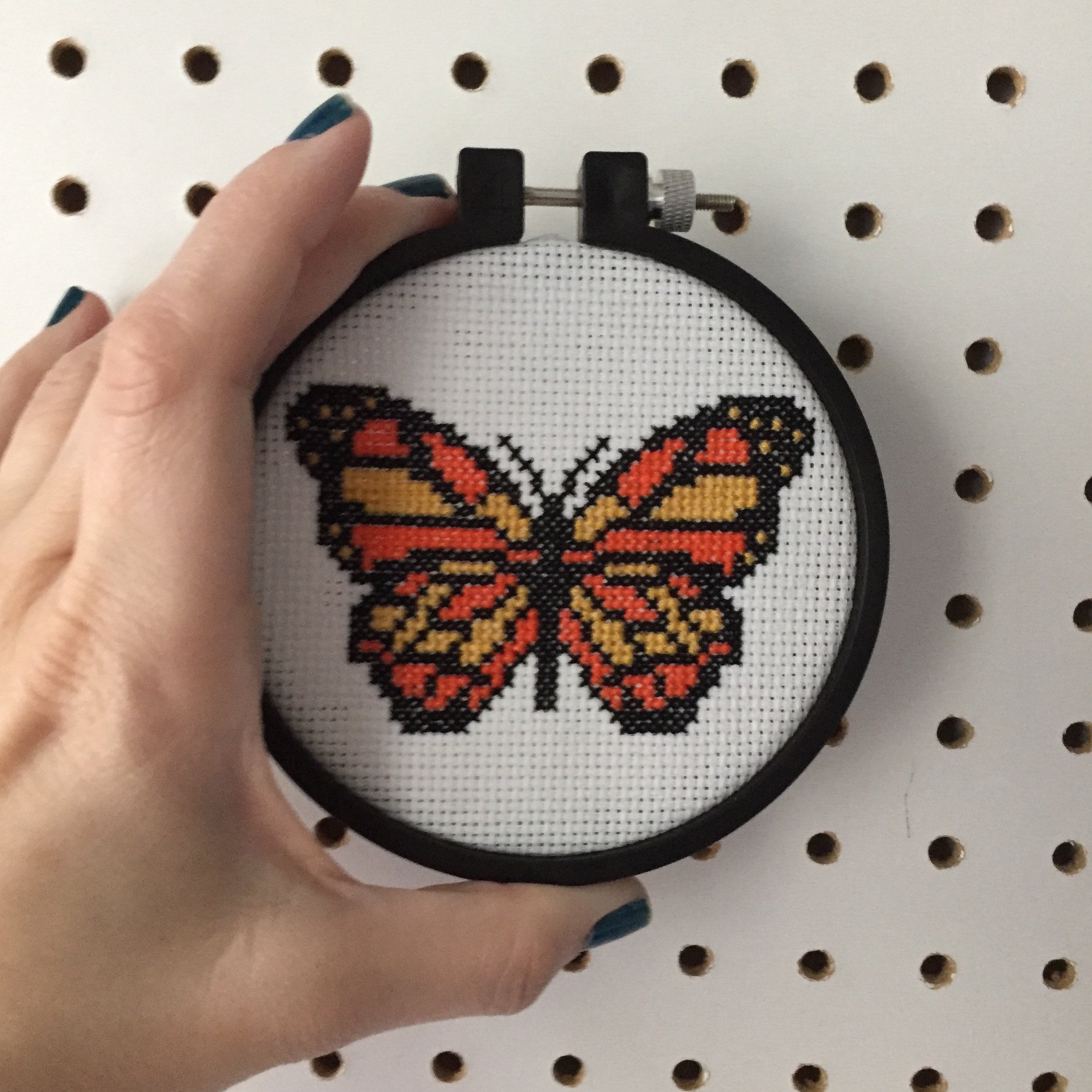 A vibrant counted cross stitch kit featuring a black, yellow, and orange butterfly design, complete with all necessary supplies for crafting.