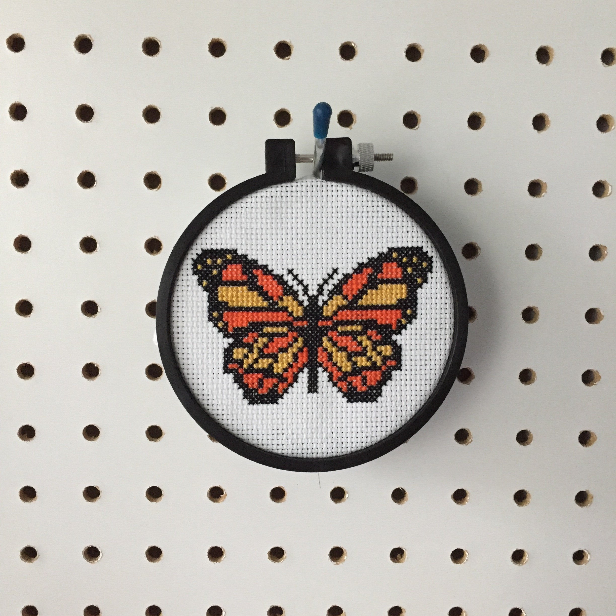 A vibrant counted cross stitch kit featuring a black, yellow, and orange butterfly design, complete with all necessary supplies for crafting.