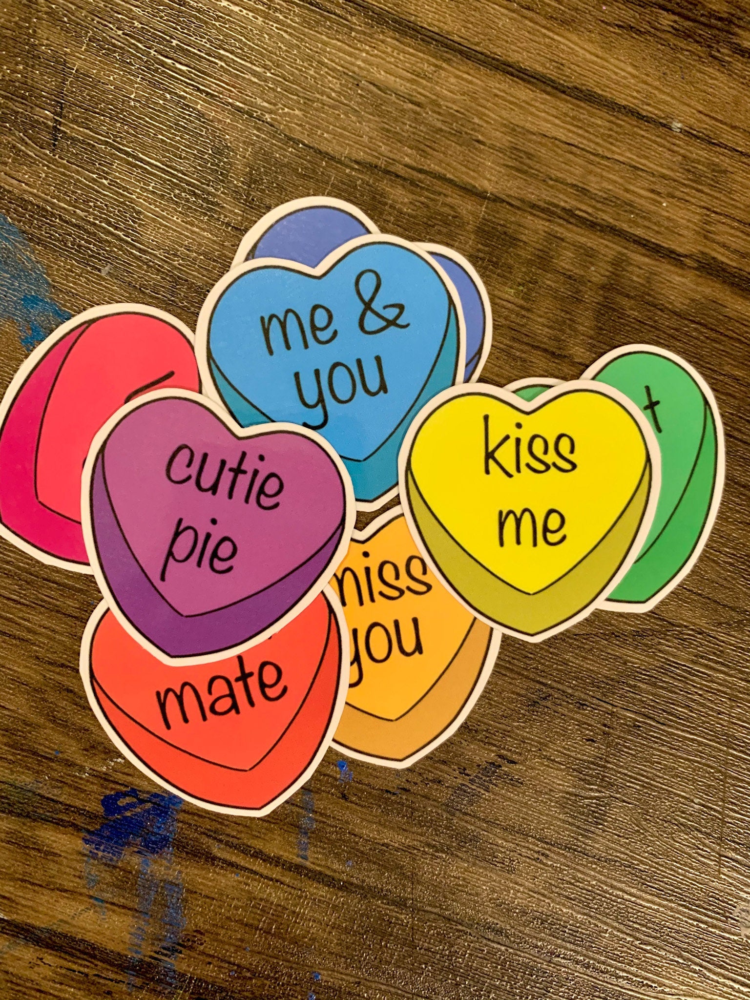 A colorful pack of 8 candy heart stickers, each measuring 2x2 inches, featuring vibrant designs perfect for personalizing items.