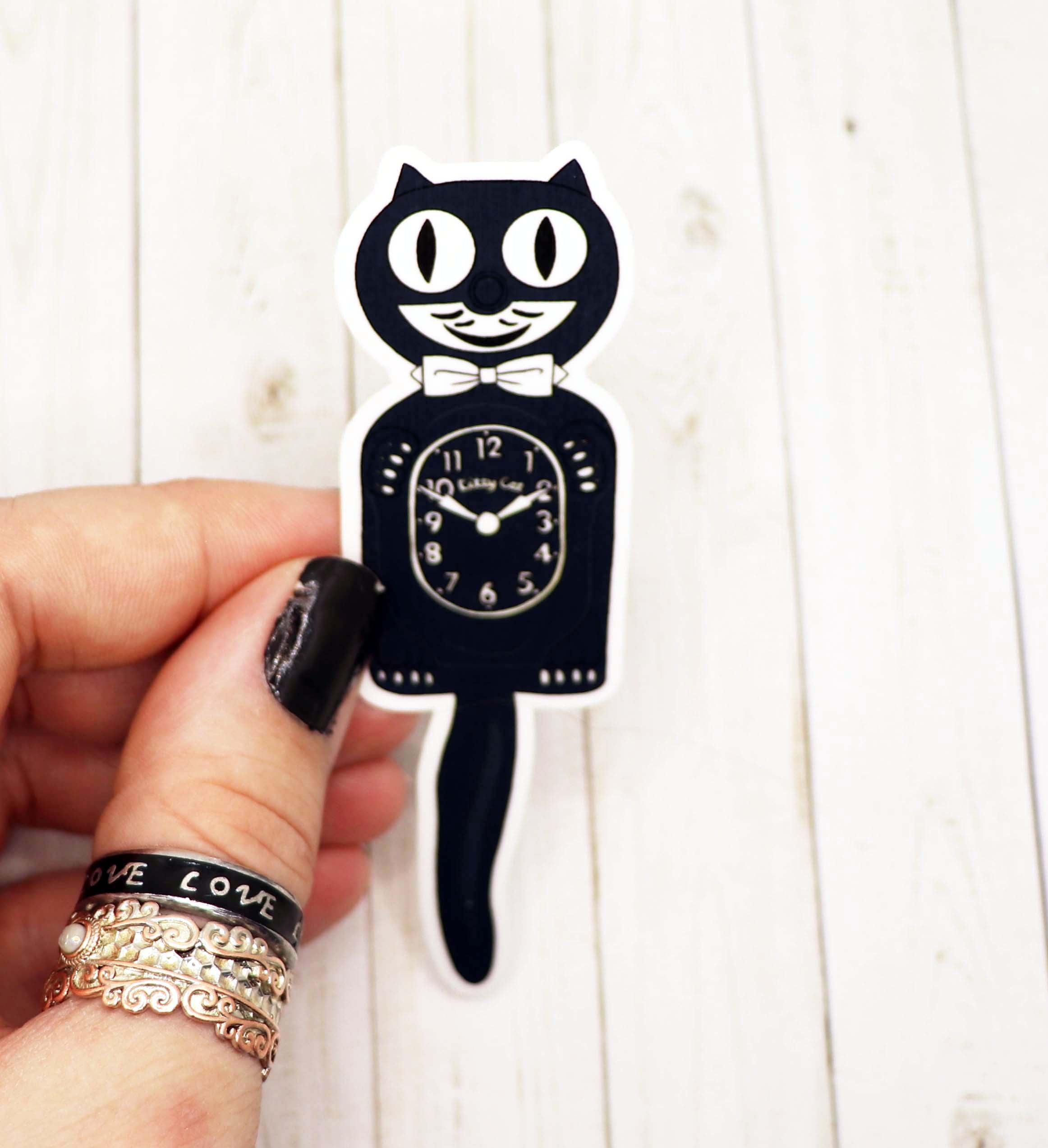 A charming Cat Clock Sticker featuring a playful cat design, measuring 4 inches wide, made from high-quality matte vinyl.