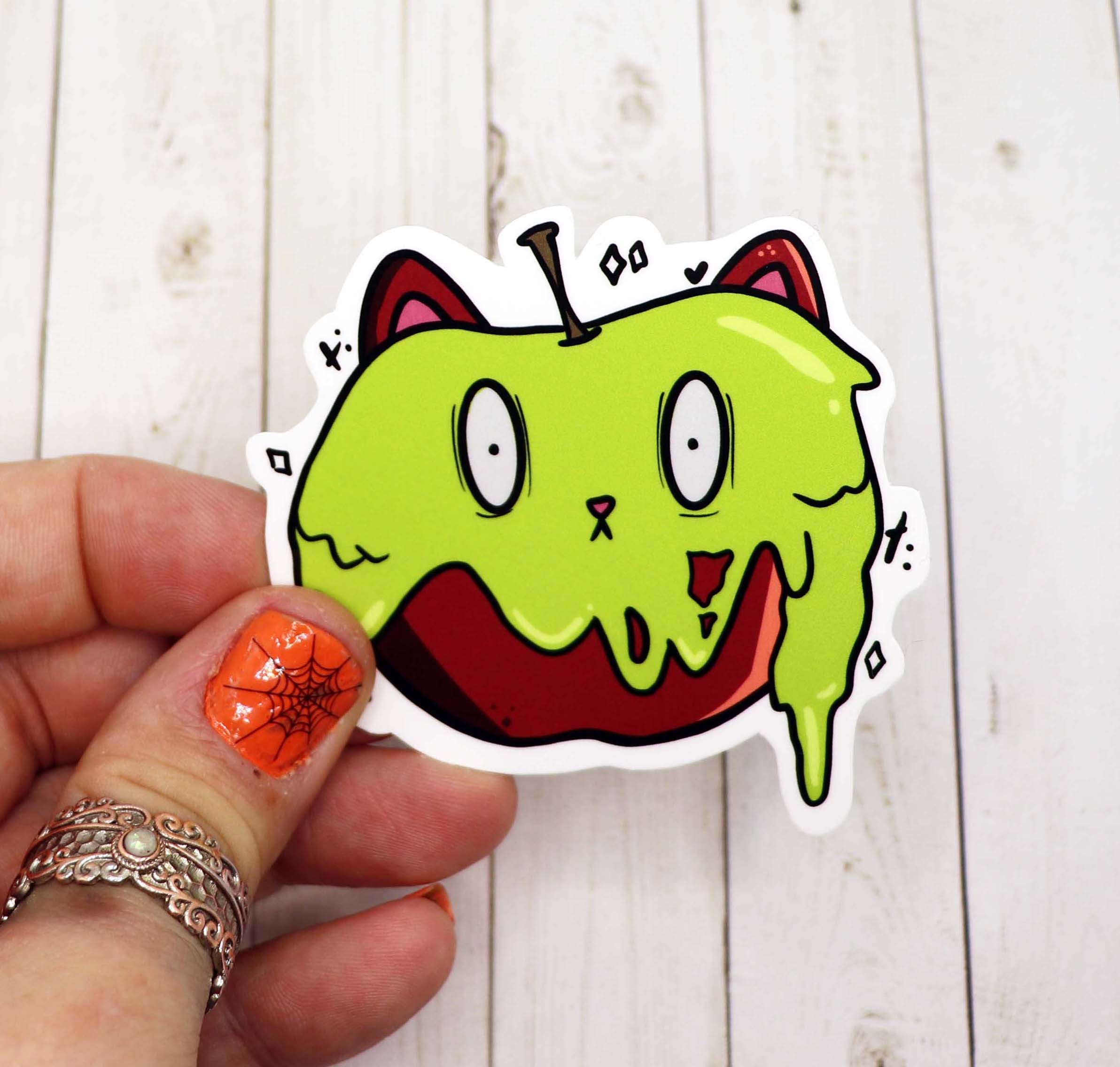 A vibrant Cat Poison Apple Vinyl Sticker featuring a whimsical cat design, perfect for personalizing various items.