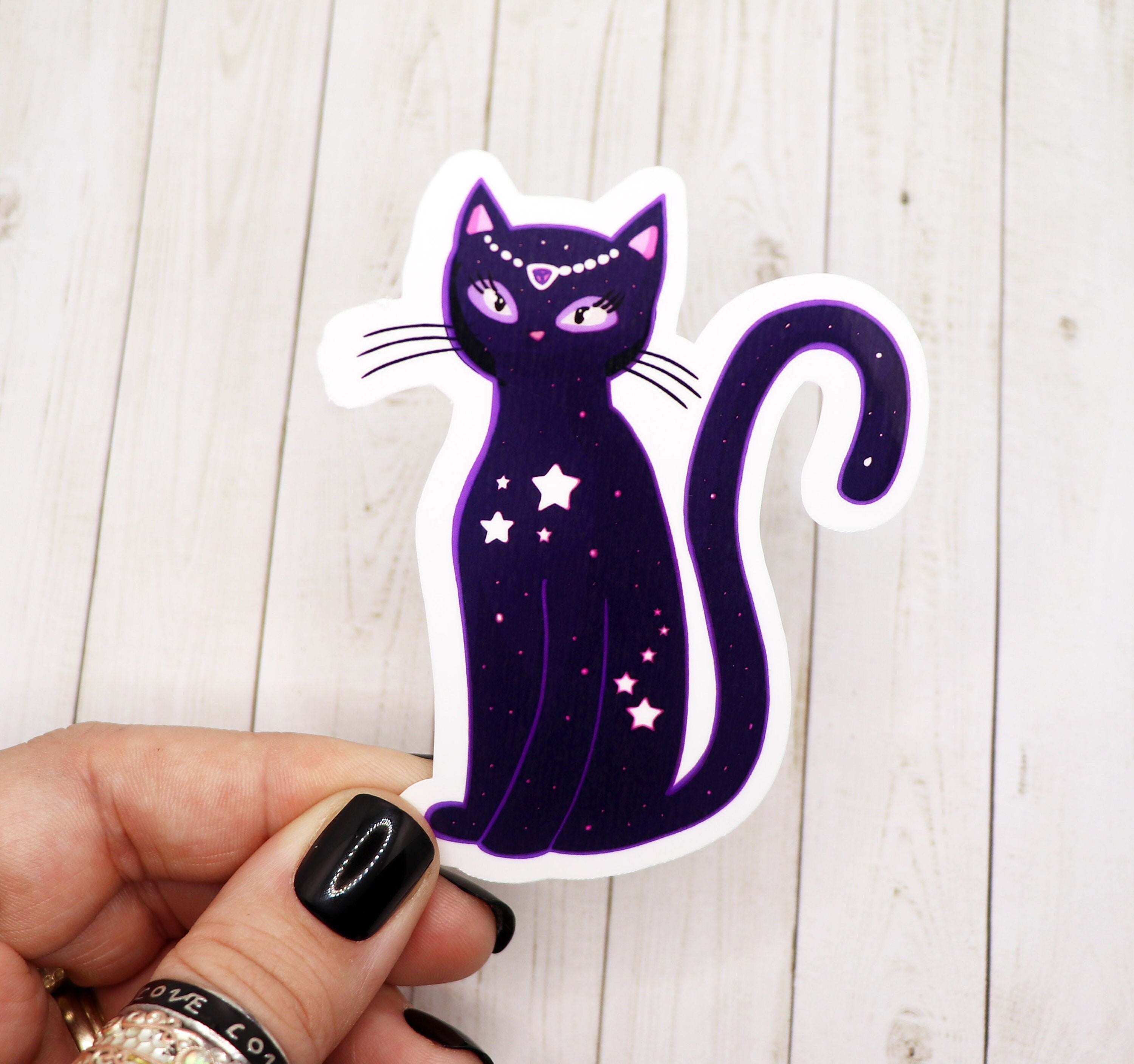 A vibrant Celestial Star Cat Sticker featuring a whimsical cat design surrounded by celestial elements, printed on matte vinyl.