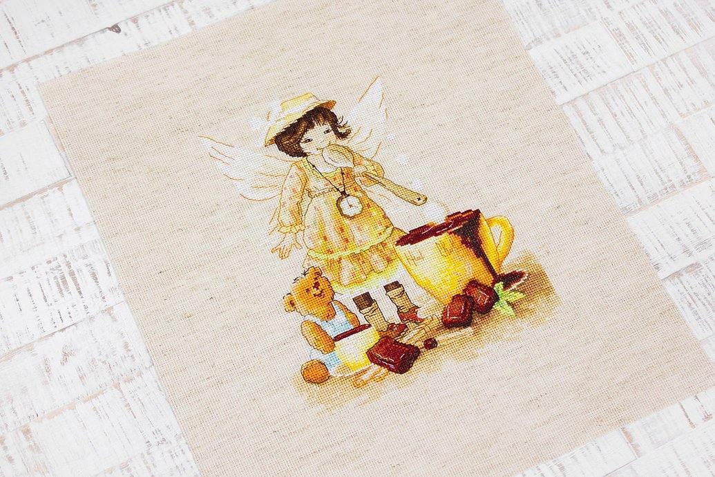 Chocolate Fairy B1131L Counted Cross-Stitch Kit featuring a fairy with hot chocolate and teddy bear on rustic canvas.