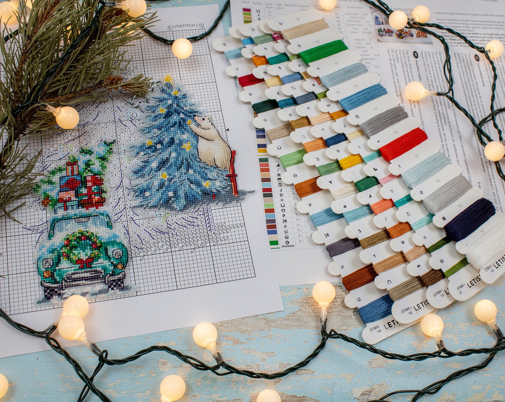 Christmas Ornaments Kit L8051 featuring vibrant colors, needle, and instructions on a plastic canvas.