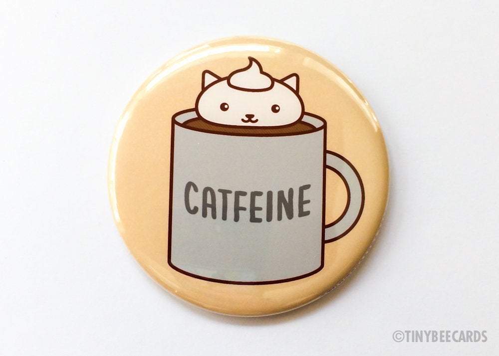 A round button featuring an adorable coffee cat design with the pun text 'Catfeine', available as a magnet or pin.