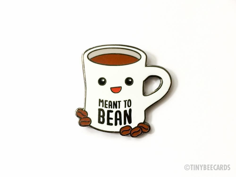 Cute hard enamel pin featuring kawaii coffee cup and coffee beans with pun text 'meant to bean'.